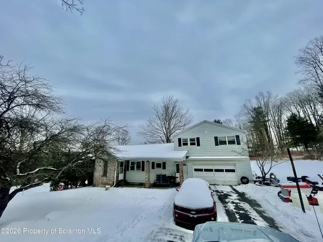 a roof deck with table and chairs and potted plants