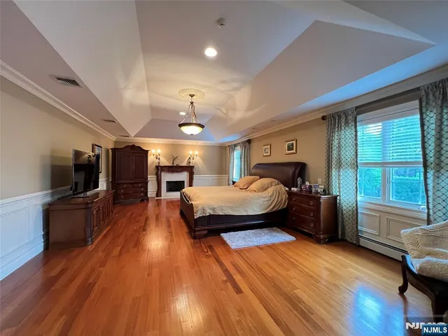 a spacious bedroom with a bed and a flat screen tv