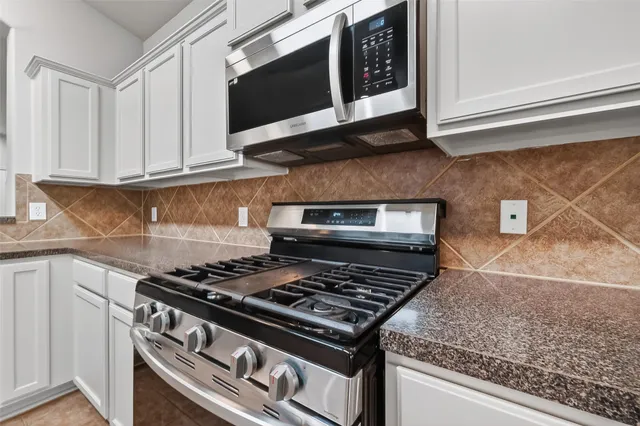 a stove top oven sitting inside of a kitchen