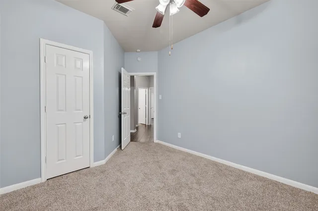 an empty room with chandelier fan