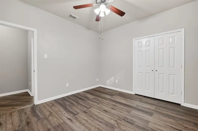 a view of an empty room with wooden floor