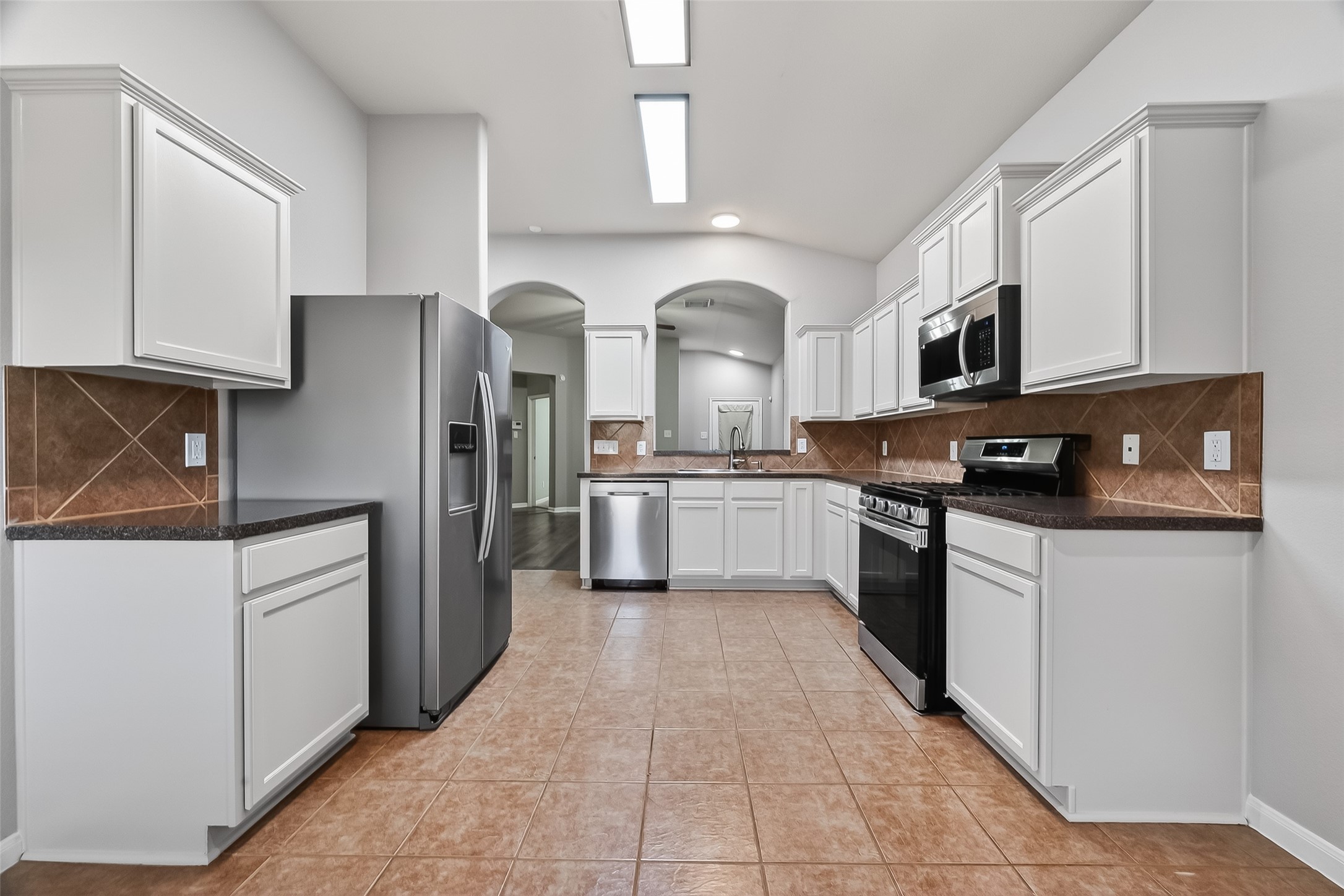 22419 Toronado Ridge Lane Porter, TX 77365 - Photo 9 of 35 a kitchen with stainless steel appliances granite countertop a refrigerator and a stove top oven