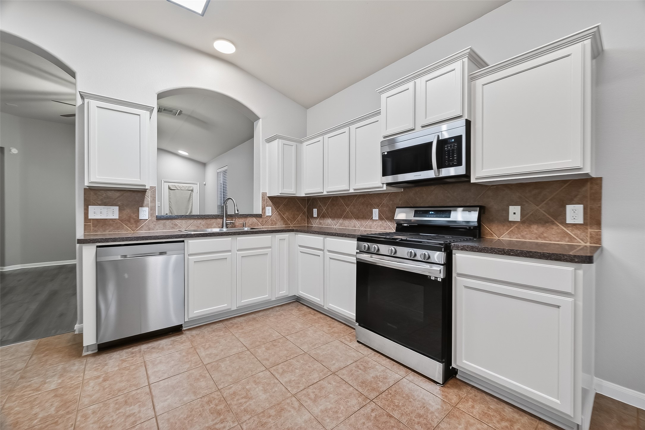 22419 Toronado Ridge Lane Porter, TX 77365 - Photo 10 of 35 a kitchen with stainless steel appliances granite countertop a stove a sink and a microwave