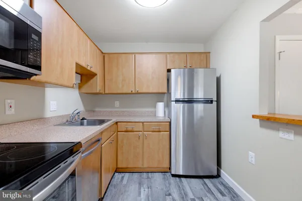 a kitchen with cabinets stainless steel appliances and a sink