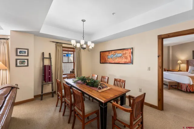 a view of a dining room with furniture and a chandelier