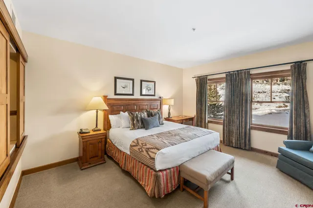 a bedroom with a bed couch and a large window