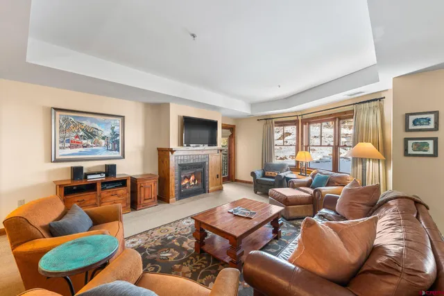 a living room with furniture fireplace and a window