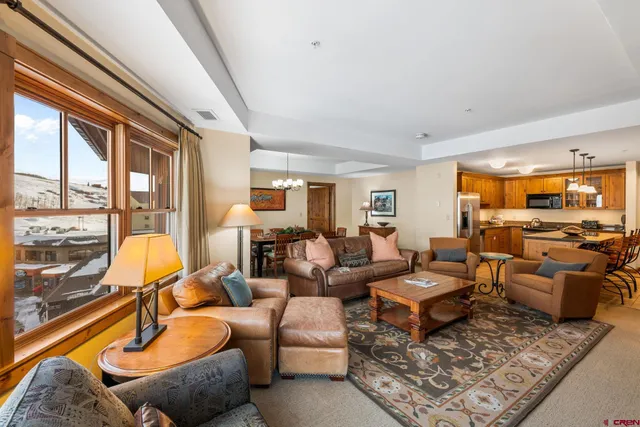 a living room with furniture and floor to ceiling windows