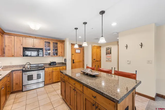 a kitchen with stainless steel appliances granite countertop a sink a stove and a wooden floors