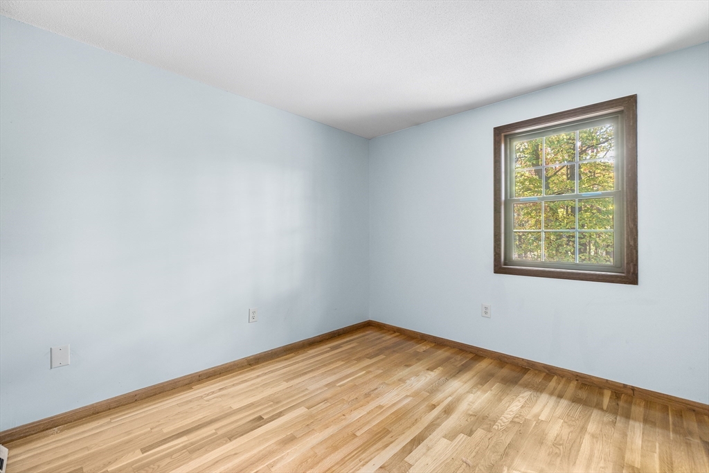 230 Irondequoit Road Franklin, MA 02038 - Photo 16 of 36 a view of an empty room with wooden floor and a window