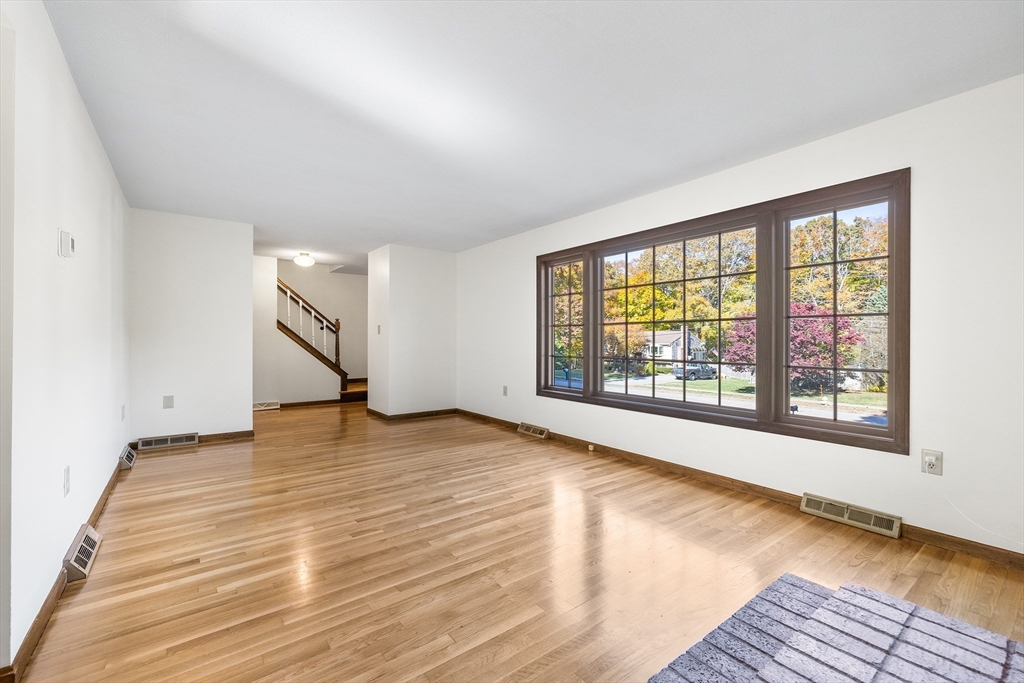 230 Irondequoit Road Franklin, MA 02038 - Photo 4 of 36 a view of an empty room with a window and wooden floor