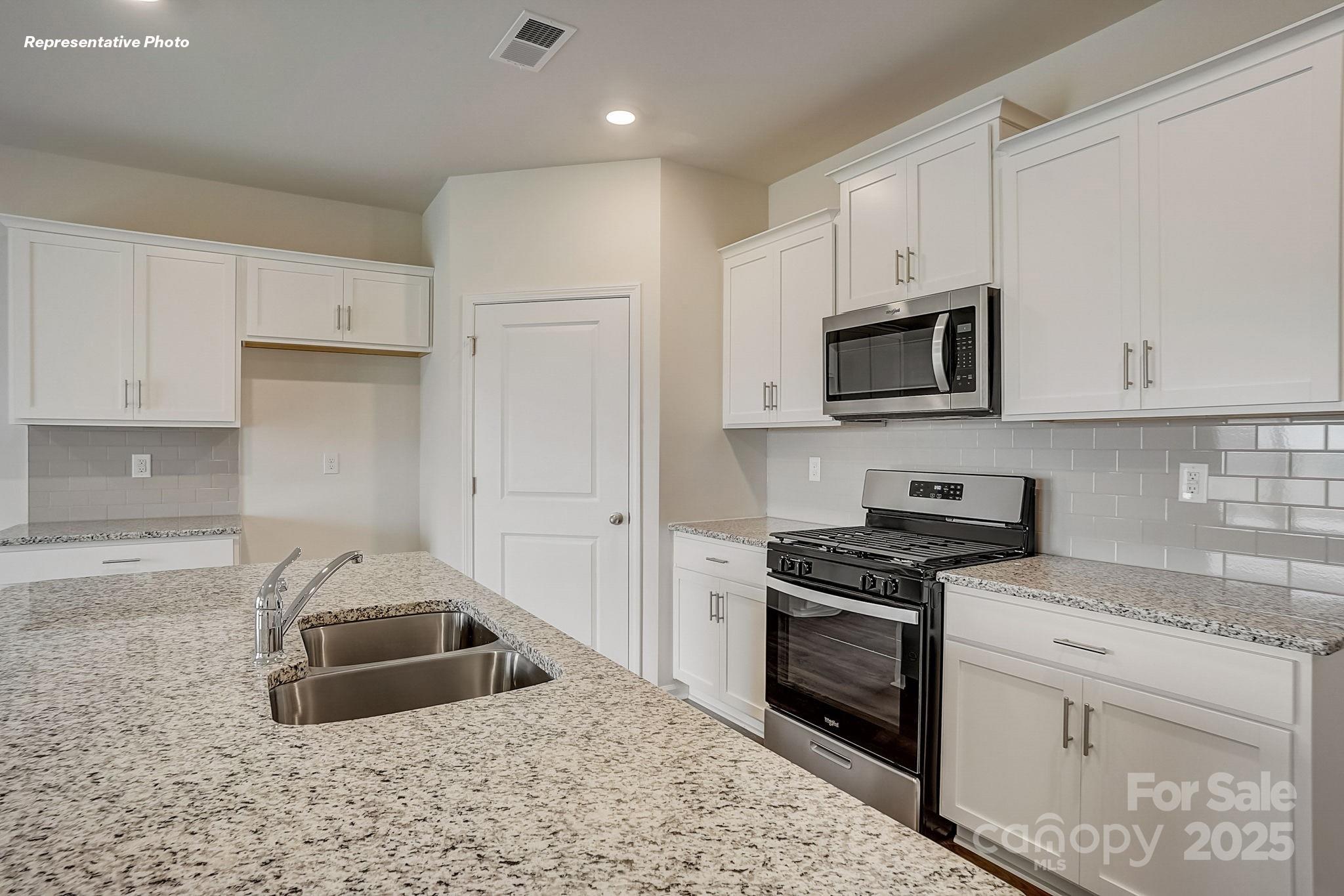 2687 Goose Fair Road Maiden, NC 28650 - Photo 8 of 24 a kitchen with granite countertop a sink a stove and cabinets