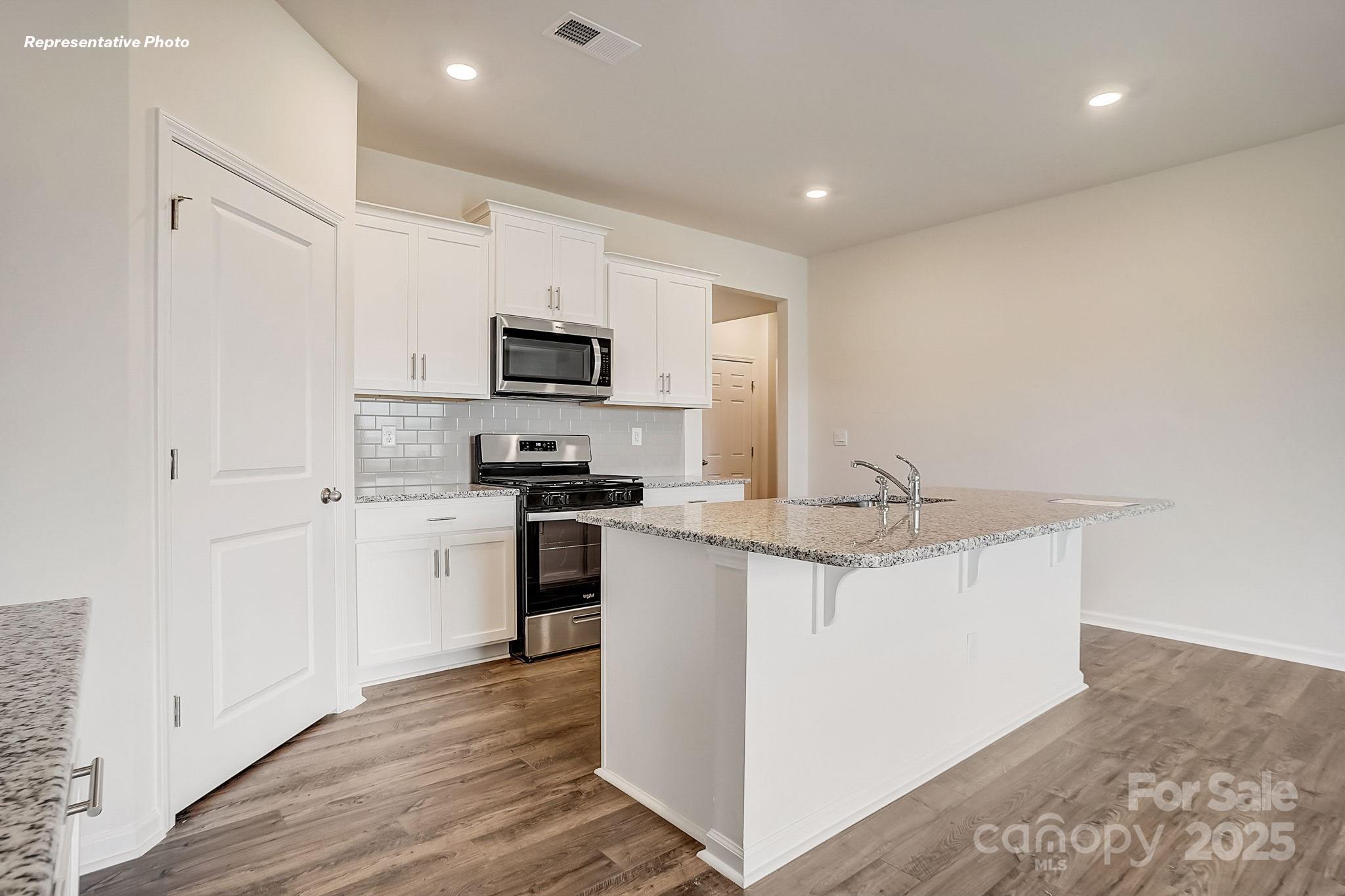 2687 Goose Fair Road Maiden, NC 28650 - Photo 9 of 24 a kitchen with kitchen island a sink stainless steel appliances and white cabinets