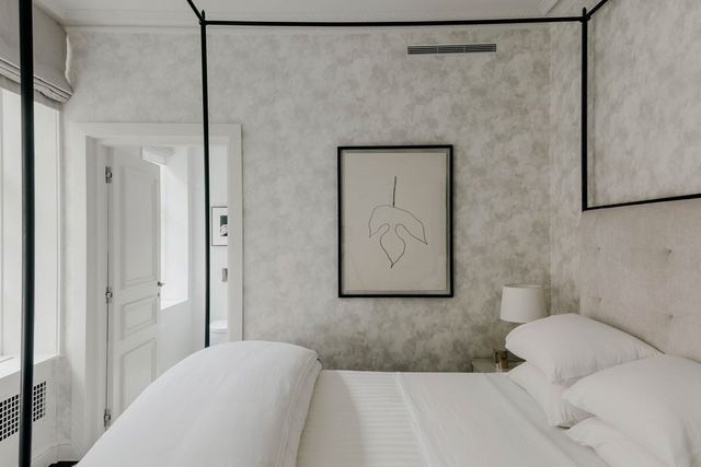 a bedroom with a bed and a painting on the wall