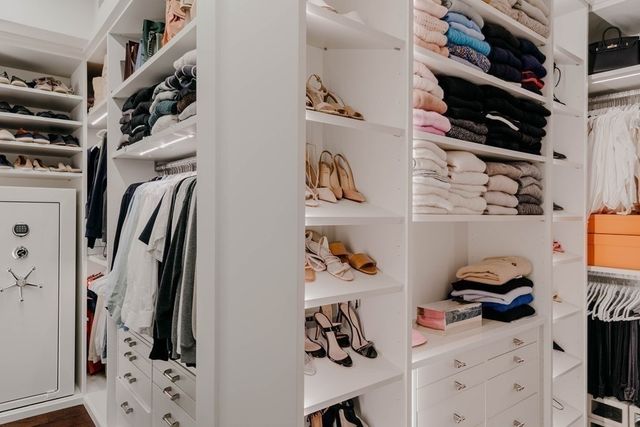 a view of walk in closet with clothes and shoes