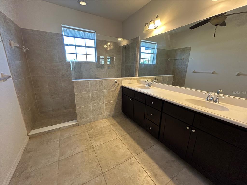 8143 Miramar Way, Unit 8143 Lakewood Ranch, FL 34202 - Photo 12 of 18 a bathroom with a double vanity sink a toilet and a mirror