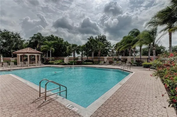 a view of a swimming pool with a patio and a yard