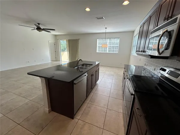 a kitchen with stainless steel appliances granite countertop a stove a sink and a microwave