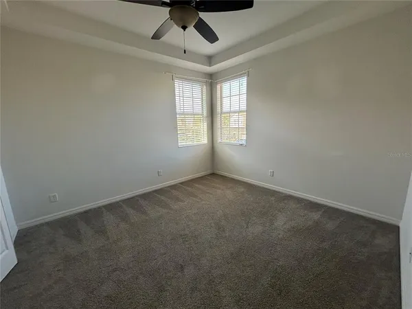 an empty room with a window and a ceiling fan
