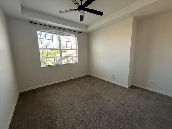 an empty room with a window and a fan