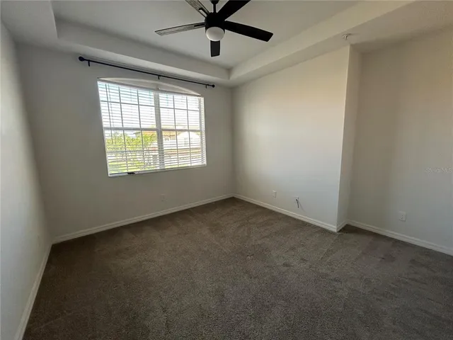 an empty room with a window and a fan