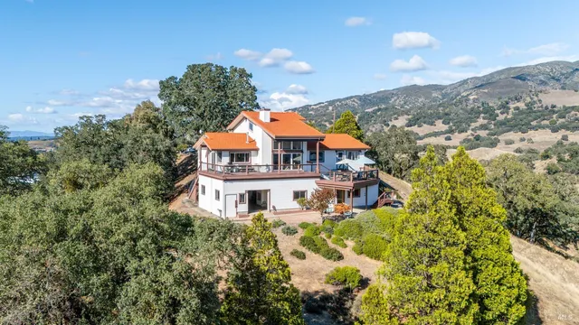 a view of a house with a big yard and large trees