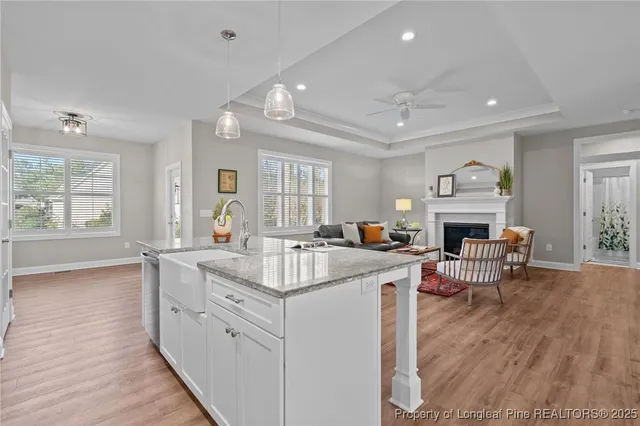 a living room with furniture kitchen view and a wooden floor