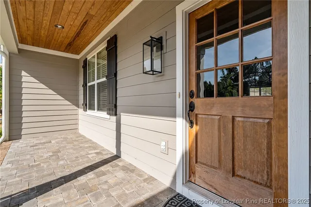 a view of an empty room with wooden floor and window