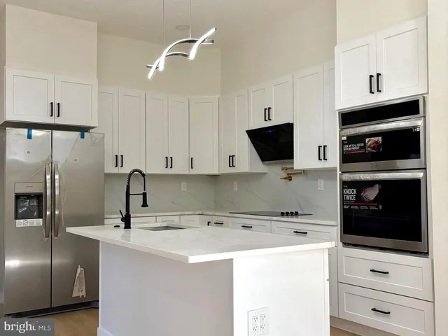 a kitchen with a refrigerator and a stove top oven