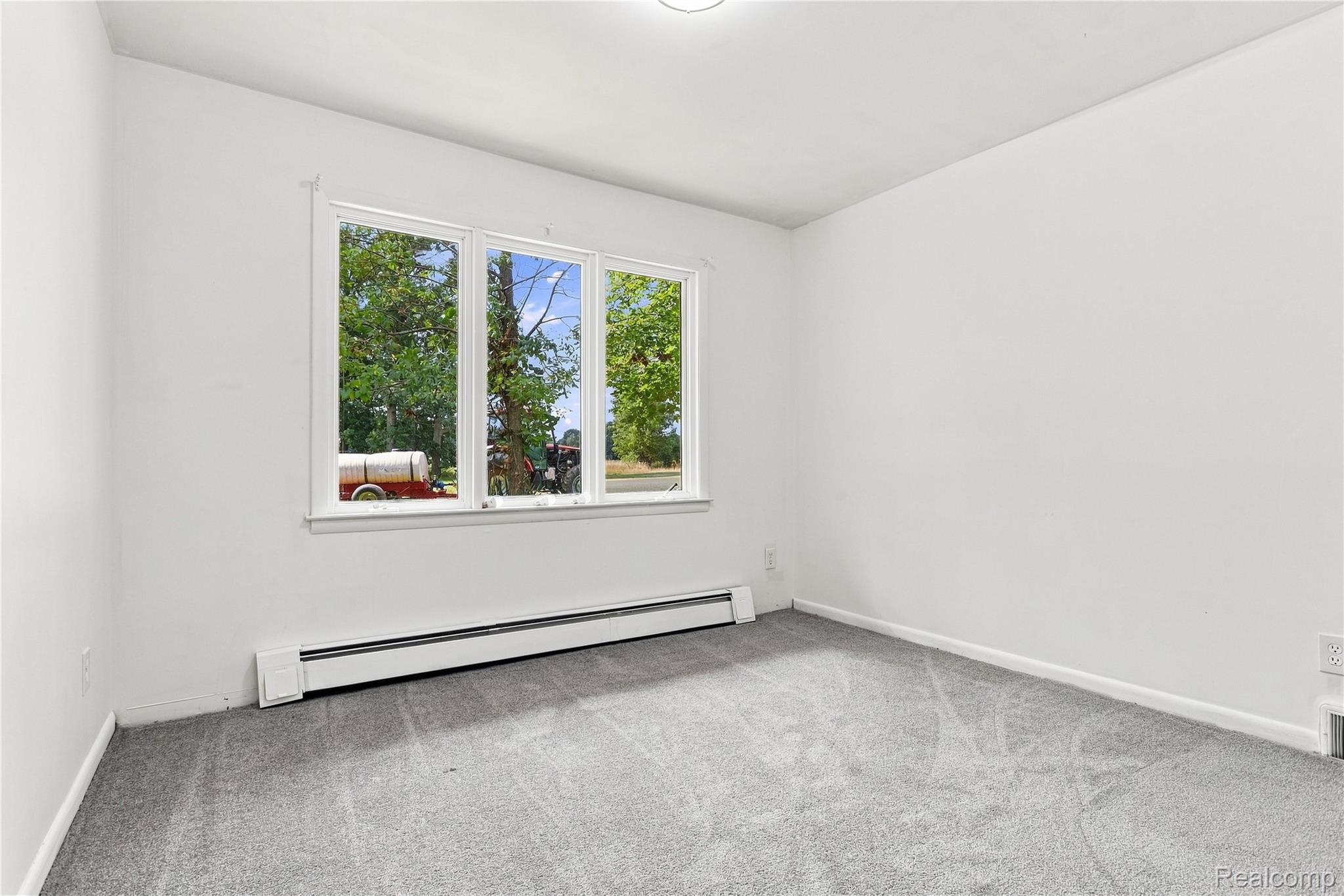7386 Dean Road Fenton, MI 48430 - Photo 12 of 64 Triple pane window, baseboard heating, and light gray carpet