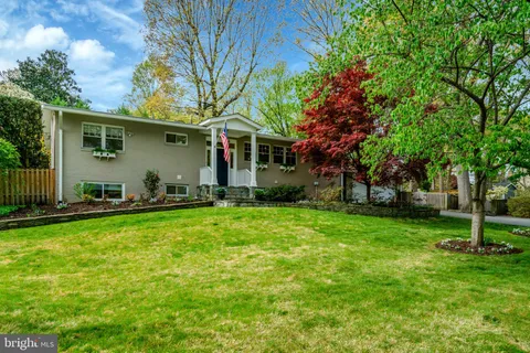 a backyard of a house with potted plants and large trees