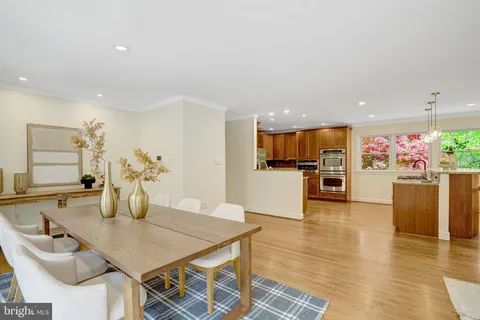 a kitchen with stainless steel appliances granite countertop a refrigerator a stove and a sink with wooden cabinets