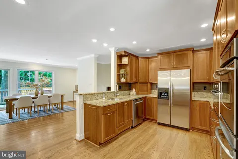a dining hall with stainless steel appliances granite countertop a stove and a dining table with garden view