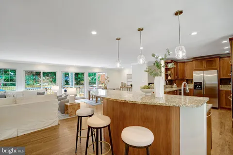 a kitchen with stainless steel appliances granite countertop a refrigerator a stove and a sink