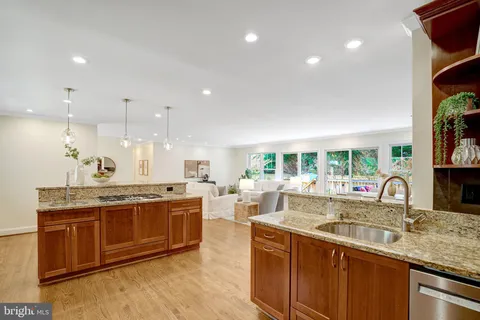 a large kitchen with kitchen island a large counter top space a sink appliances and living room view