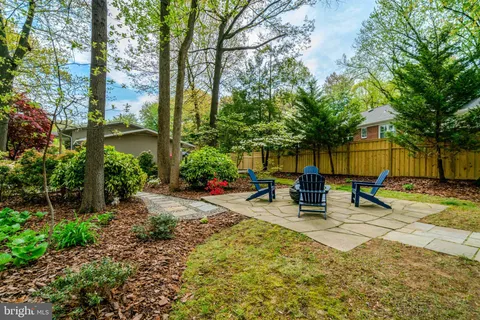 front view of a house with a yard and an trees