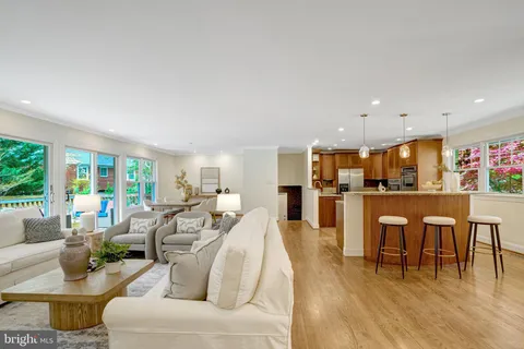 a living room with furniture dining table a large window and kitchen view