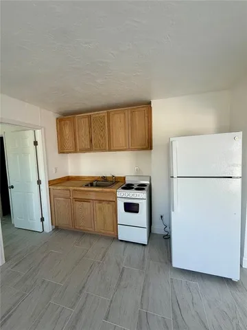 a kitchen with a refrigerator and a stove top oven
