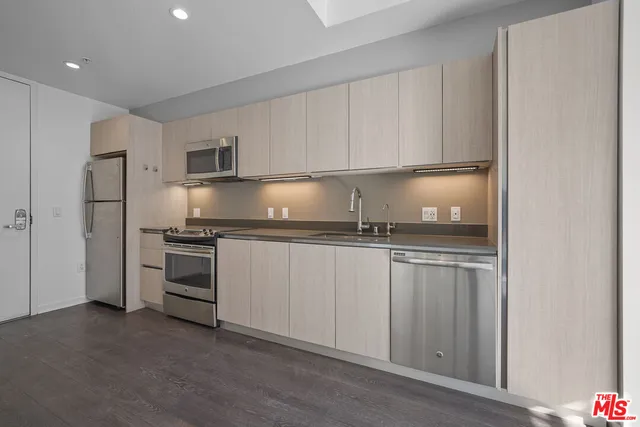 a kitchen with stainless steel appliances granite countertop a refrigerator sink and stove