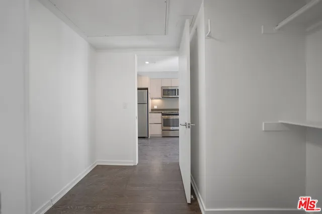 a view of a hallway with wooden shelves