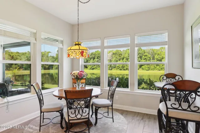 a dining room with furniture a chandelier and wooden floor