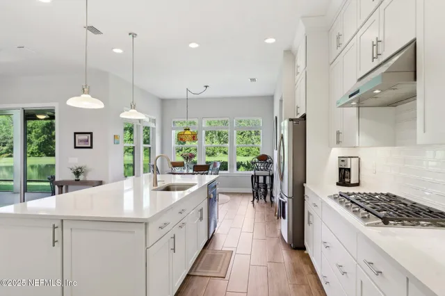 a kitchen with kitchen island a counter space a stove a sink a center island and furniture