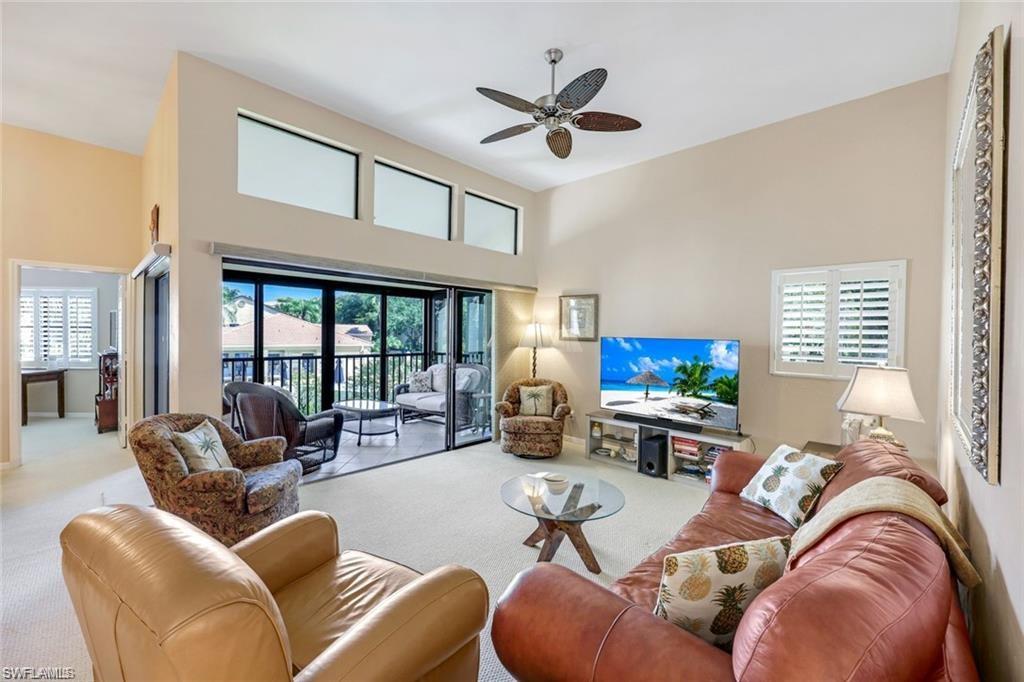6555 Valen Way, Unit G201 Naples, FL 34108 - Photo 9 of 28 a living room with furniture a fireplace and a large window