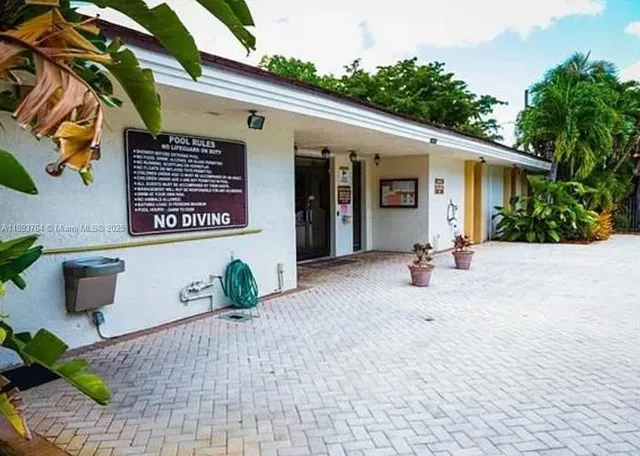 a view of a white house with potted plants