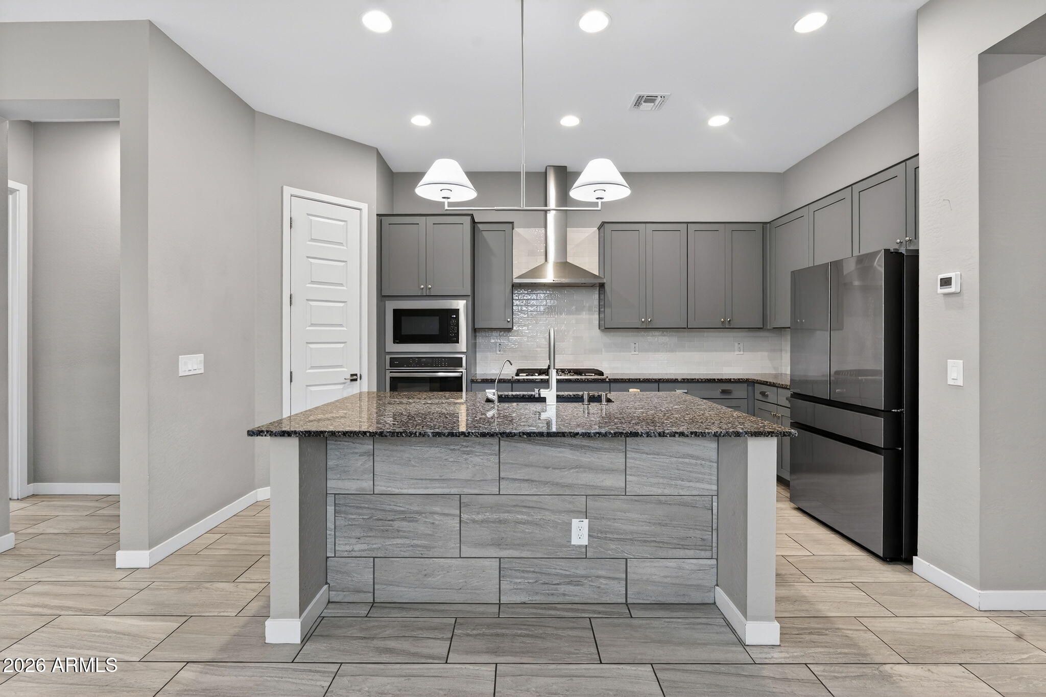 3075 East Appaloosa Road Gilbert, AZ 85296 - Photo 10 of 41 a kitchen with stainless steel appliances granite countertop a stove and a refrigerator