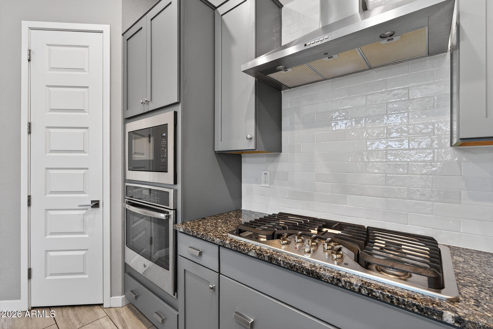 3075 East Appaloosa Road Gilbert, AZ 85296 - Photo 11 of 41 a kitchen with white cabinets and a stove top oven