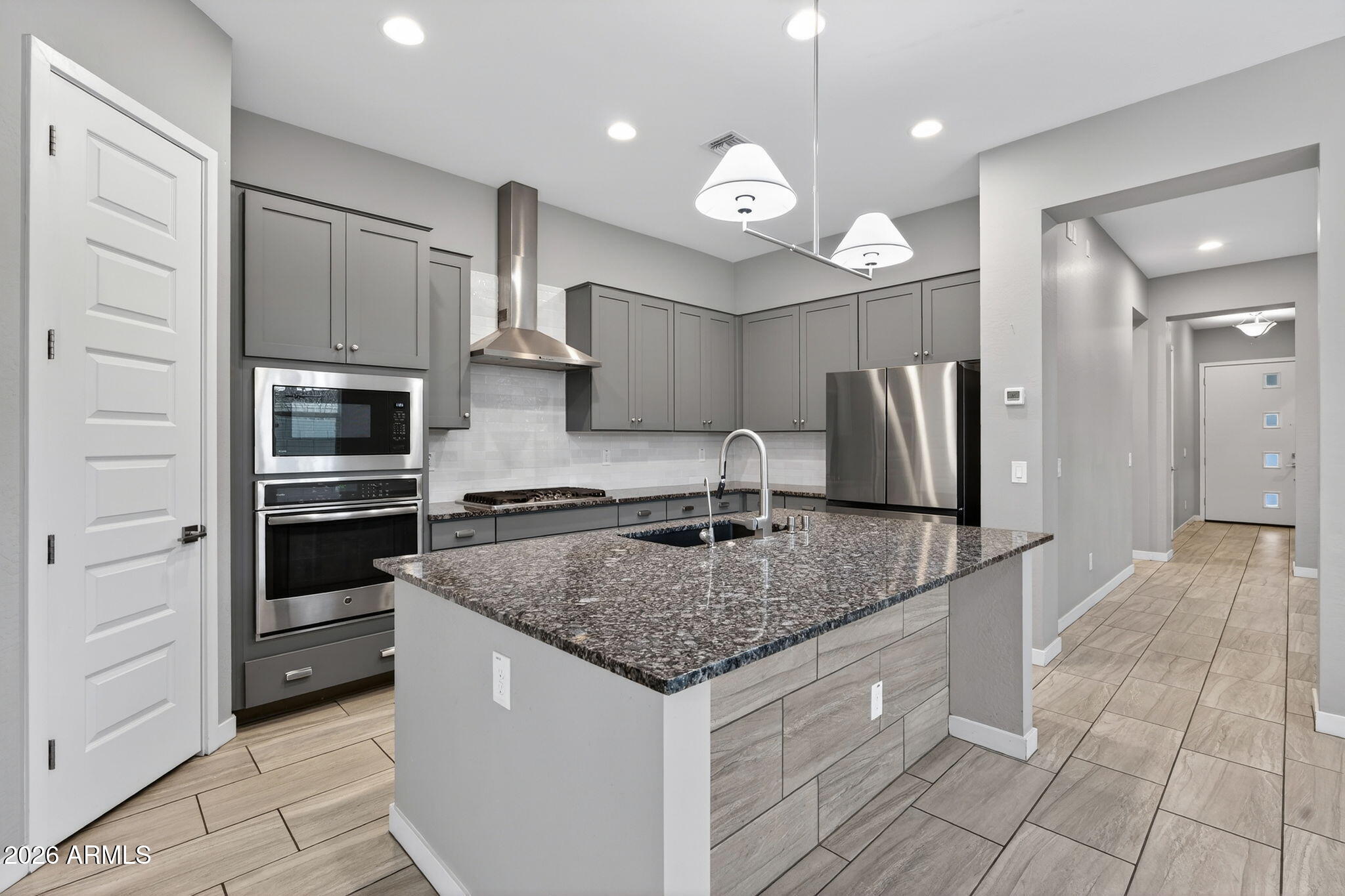 3075 East Appaloosa Road Gilbert, AZ 85296 - Photo 9 of 41 a kitchen with stainless steel appliances granite countertop a sink and a refrigerator