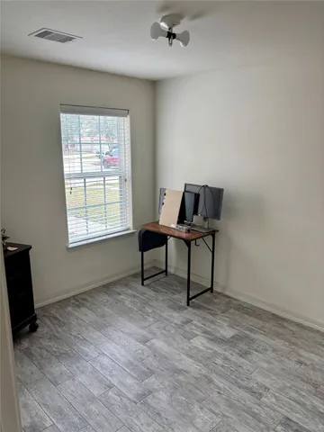 a view of a backyard with potted plants and wooden fence