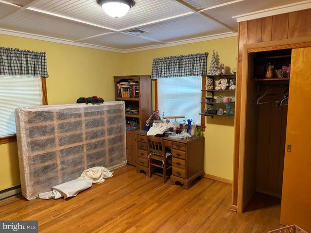 a view of a door with an empty room and wooden floor