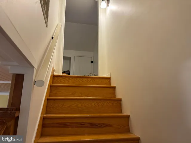 a view of a hallway with wooden floor and closet